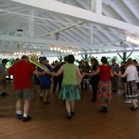 A group of people are dancing in a large room.