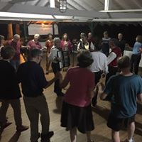 A group of people are dancing in a room.