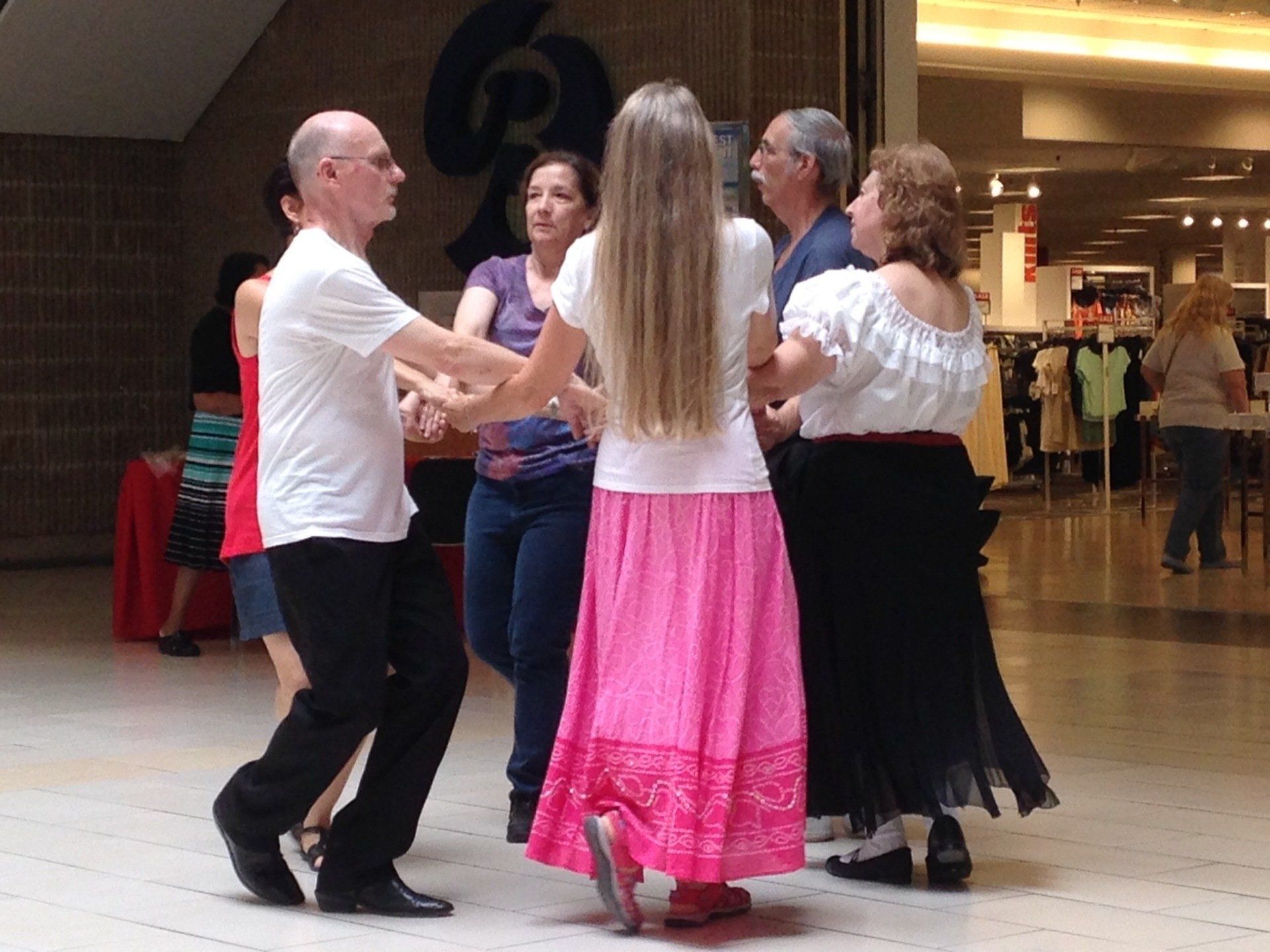 A group of people are dancing in front of a sign that says 6