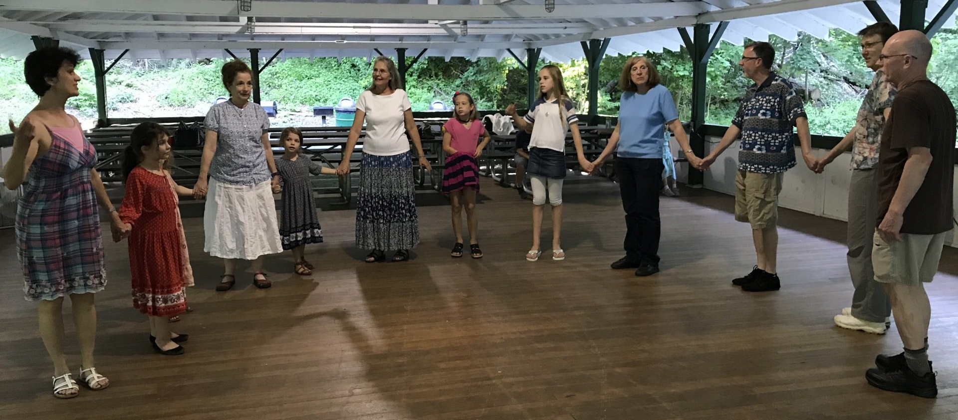 A group of people are standing in a circle holding hands