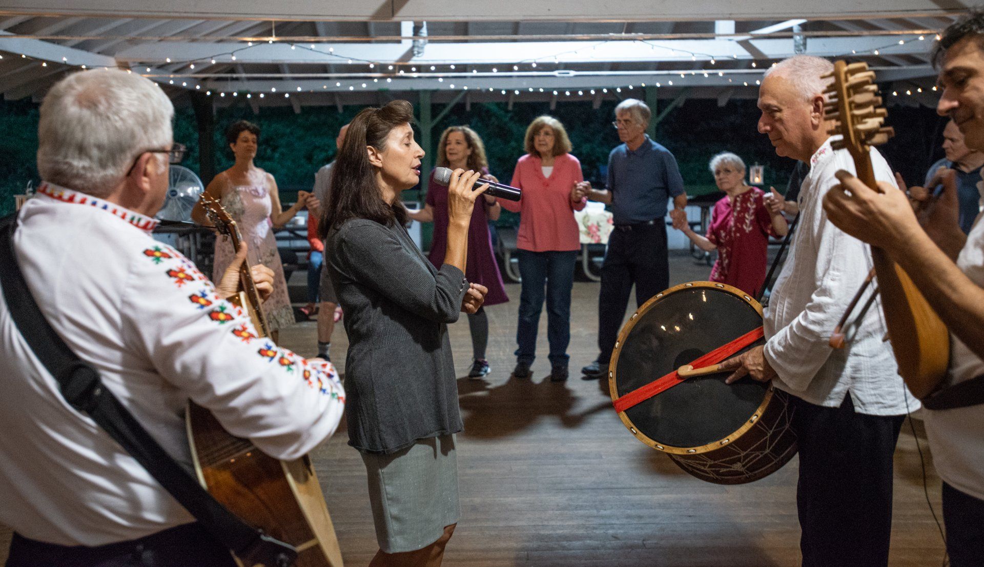A group of people are standing in a circle playing instruments.