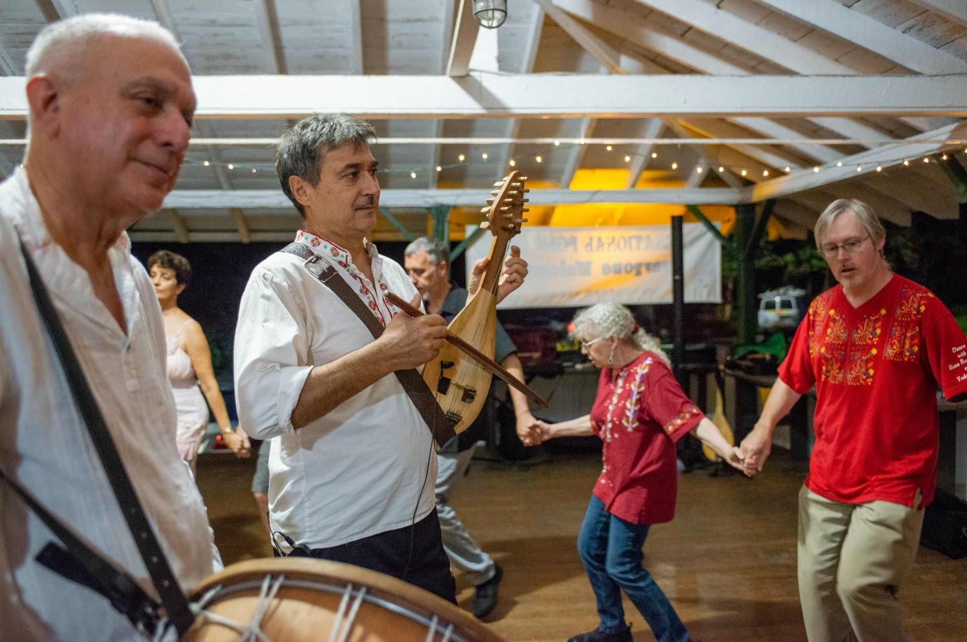A group of people are dancing and playing instruments in a room.