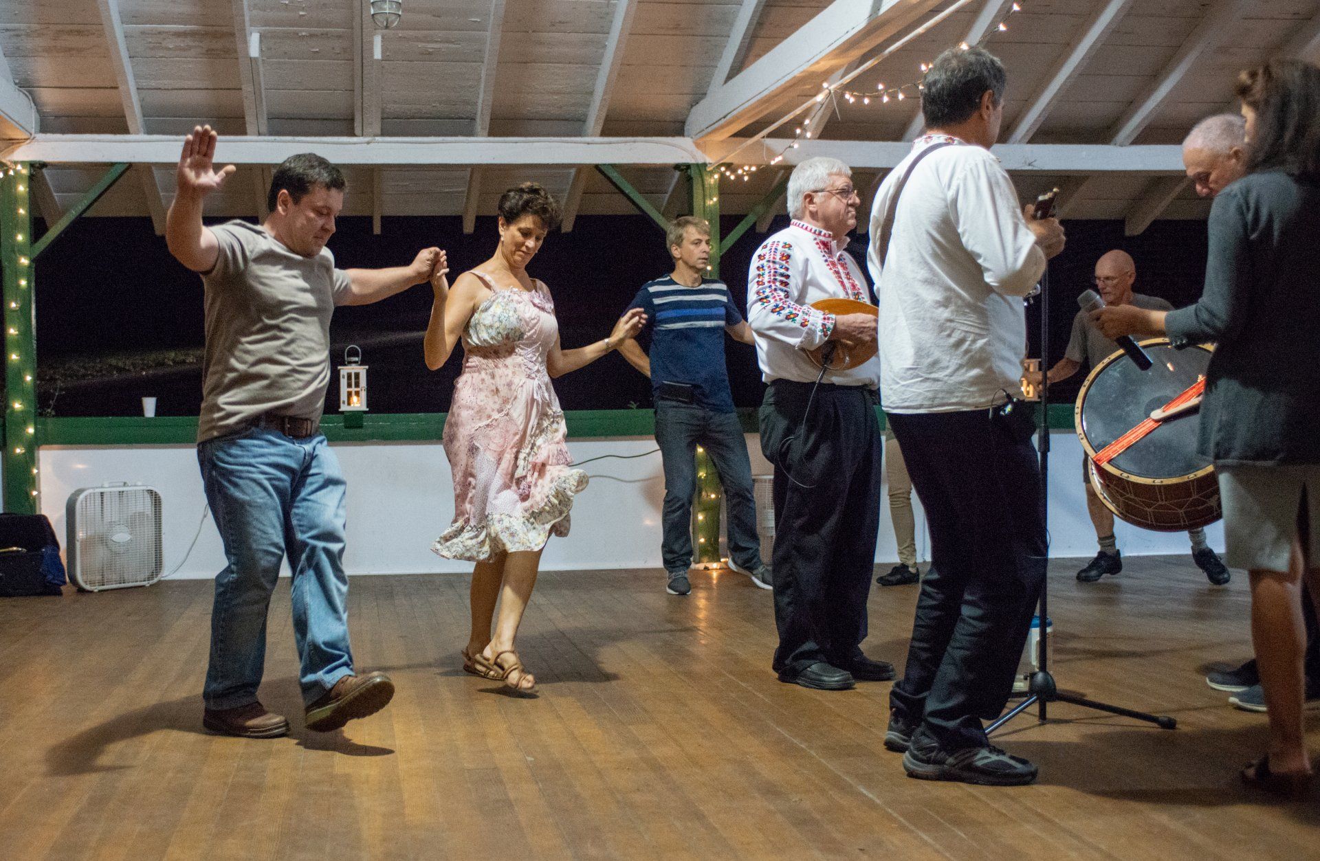 A group of people are dancing and playing instruments in a room.