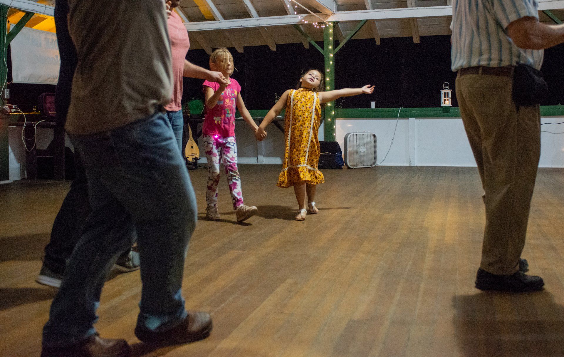 A group of people are dancing on a wooden floor