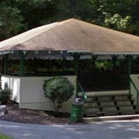 A gazebo with a canopy and stairs in a park.