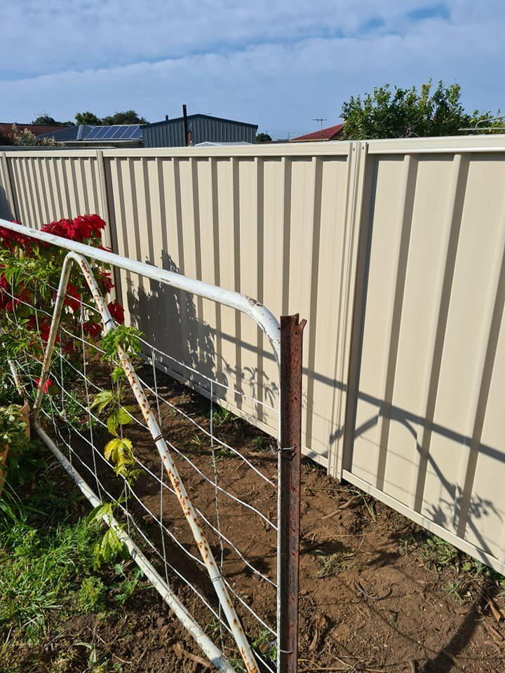 A Fence with A Gate in The Middle of A Garden — D & B Fencing in Harrington, NSW