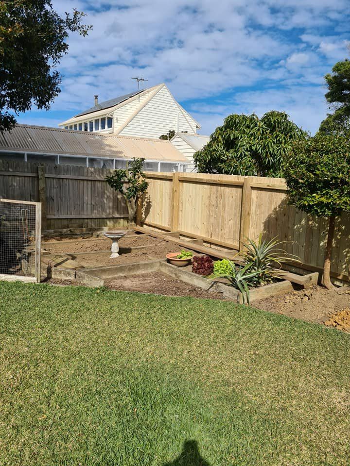A Backyard with A Wooden Fence and A House in The Background — D & B Fencing in Taree, NSW
