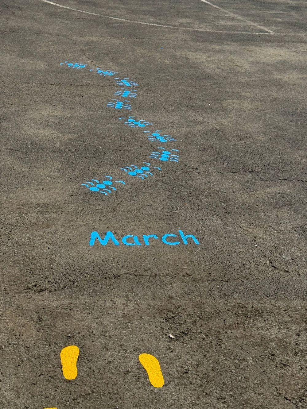 The word march is painted on the ground with blue paint