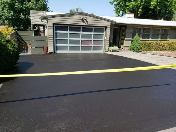 A house with a garage and a black driveway