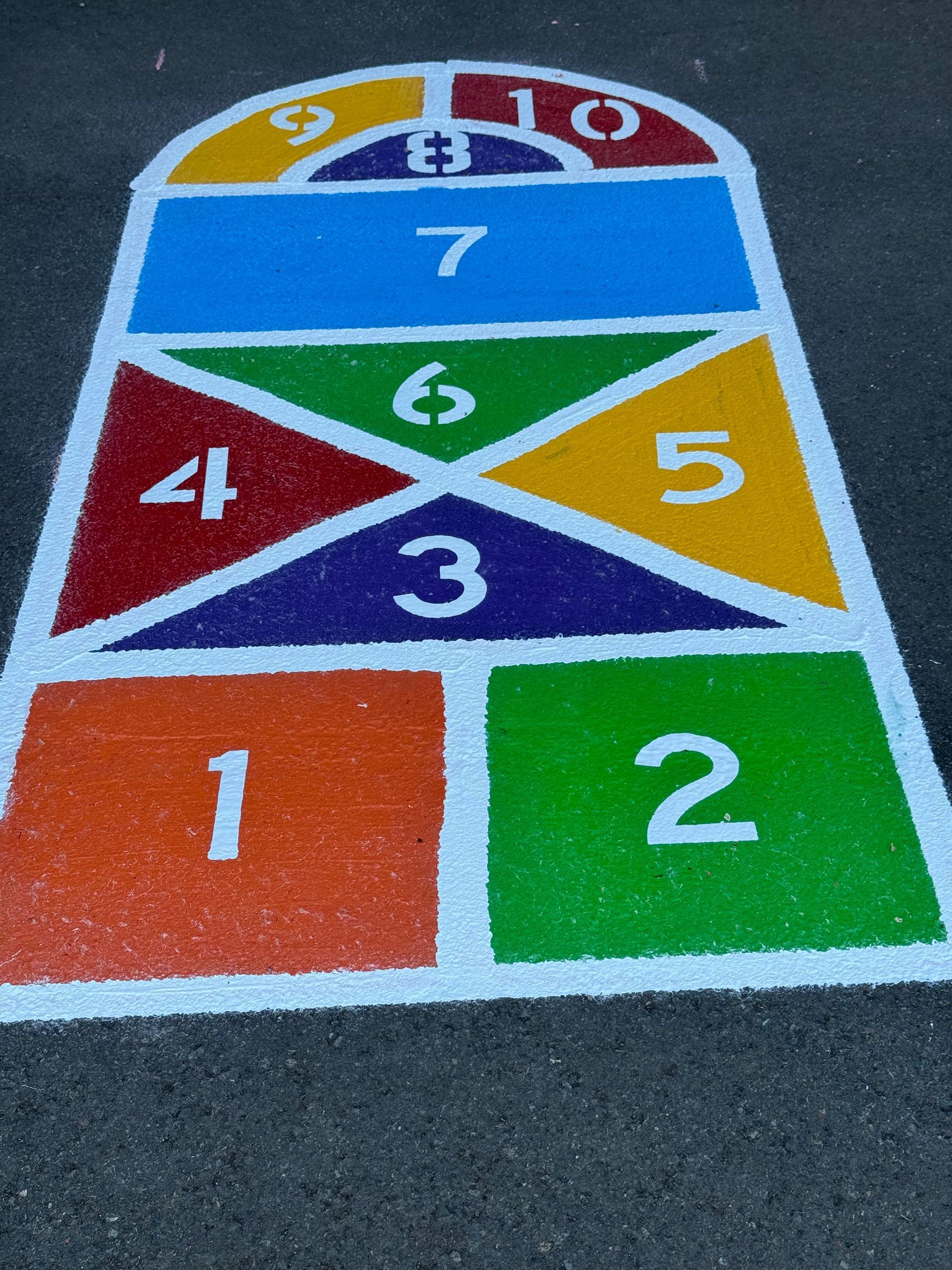 A colorful hopscotch game is painted on the ground