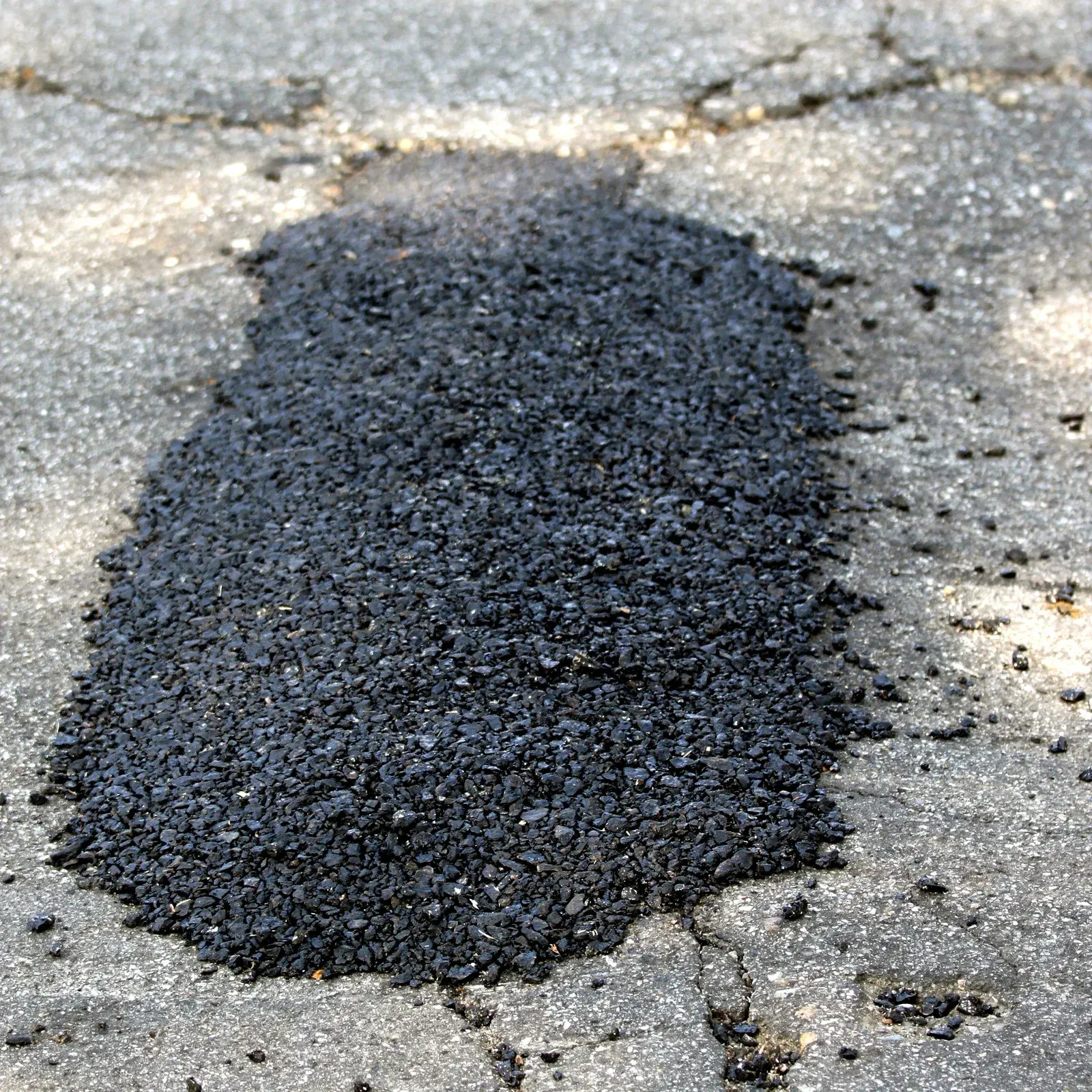 A close up of a concrete surface with a lot of small rocks on it.