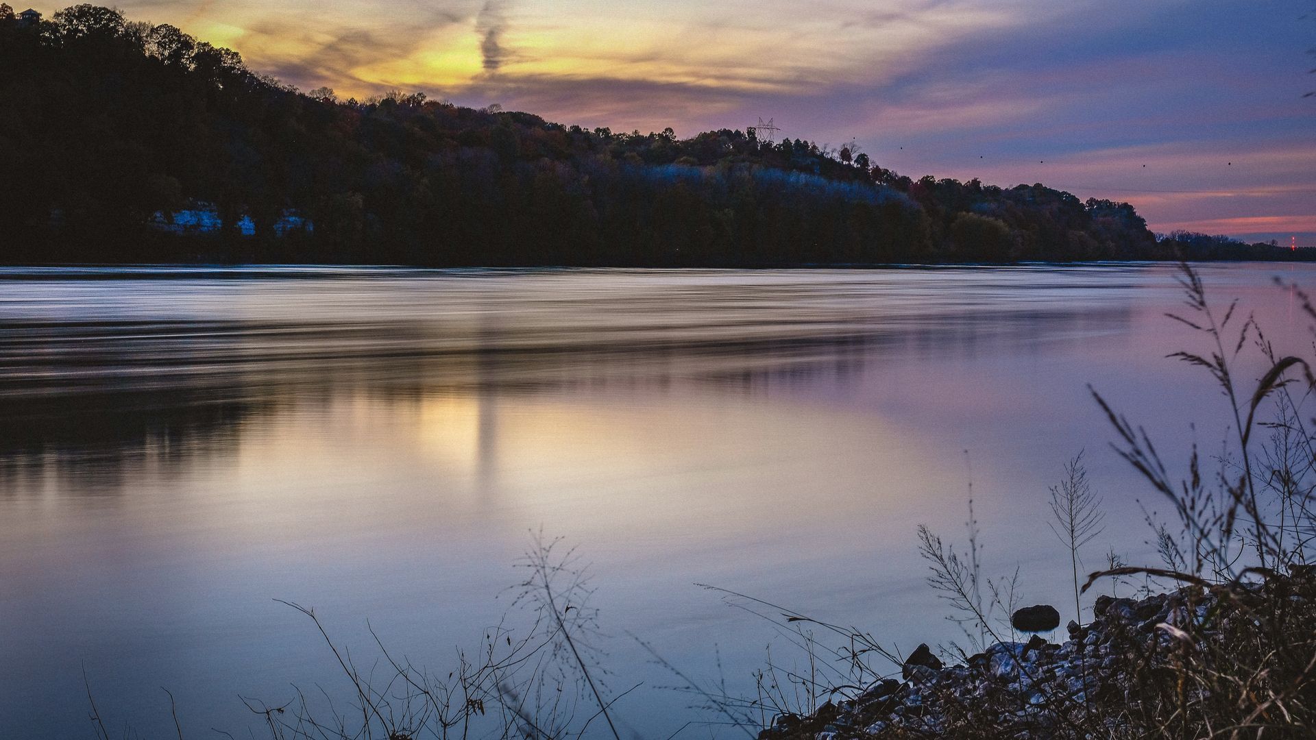 A large body of water with a sunset in the background.