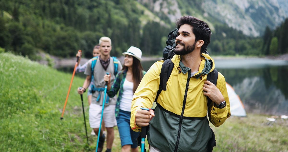 A group of people are hiking in the mountains near a lake.