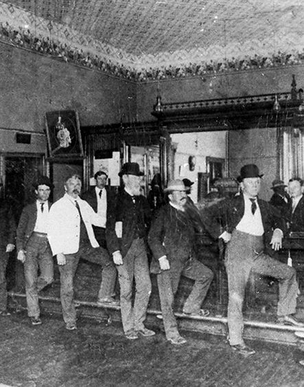 A group of men are standing on a bar in a black and white photo.