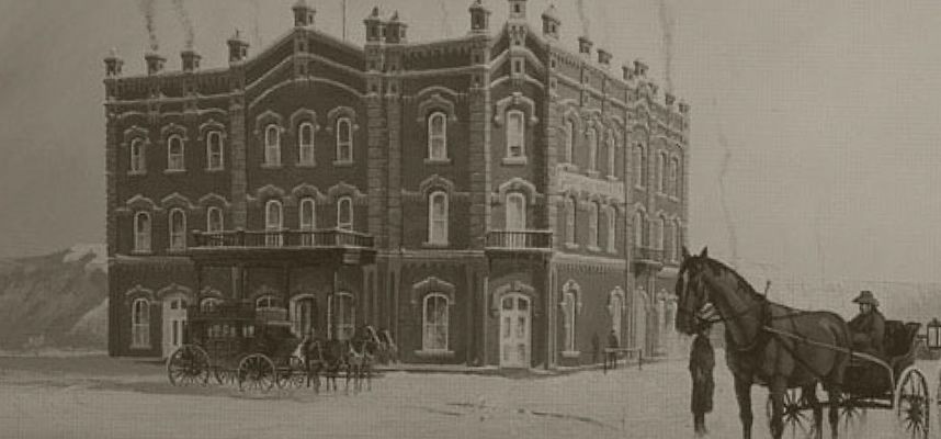 A black and white photo of a horse drawn carriage in front of a large building.