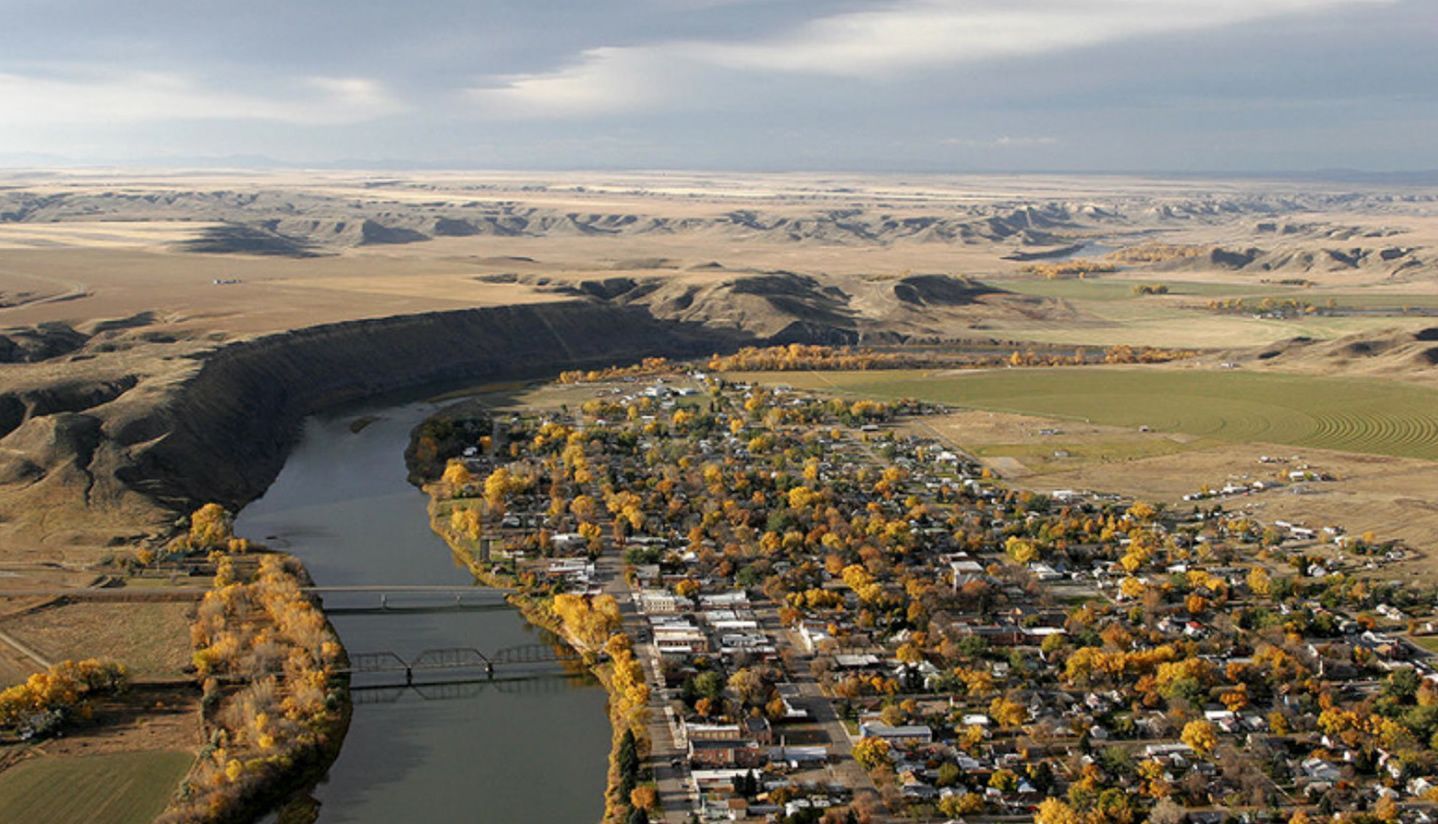 An aerial view of a river flowing through a small town.