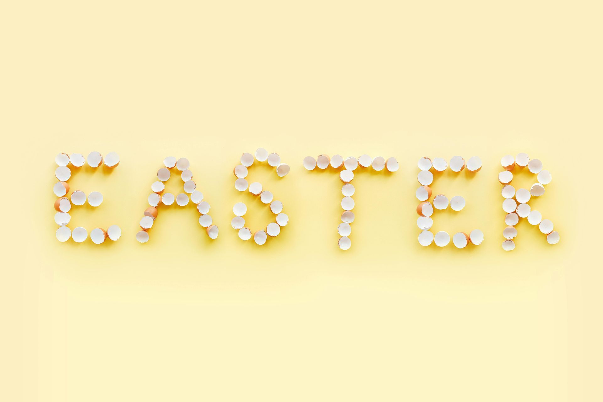 The word easter is made of easter eggs on a yellow background.