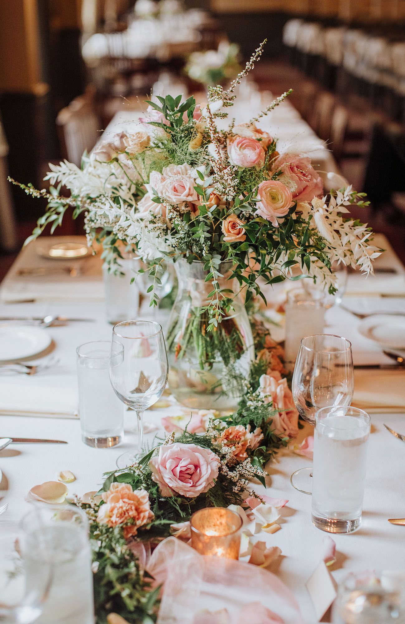 A long table with a vase of flowers on it.