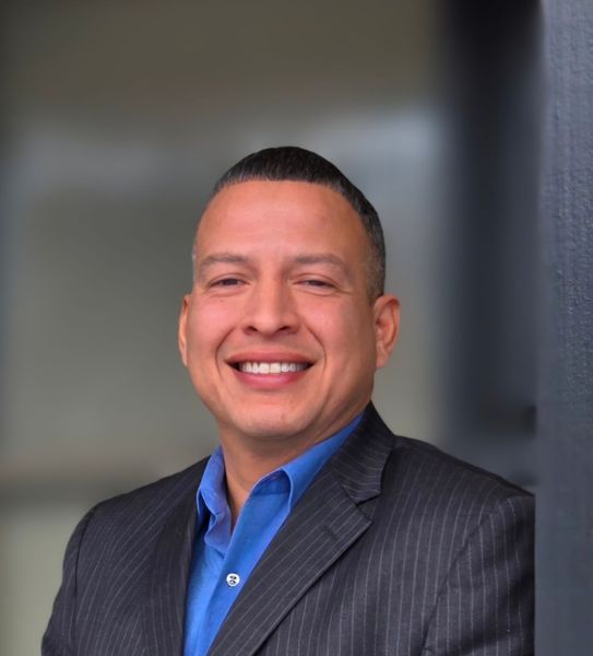 Headshot of Danny Cruz with a blurred background. 