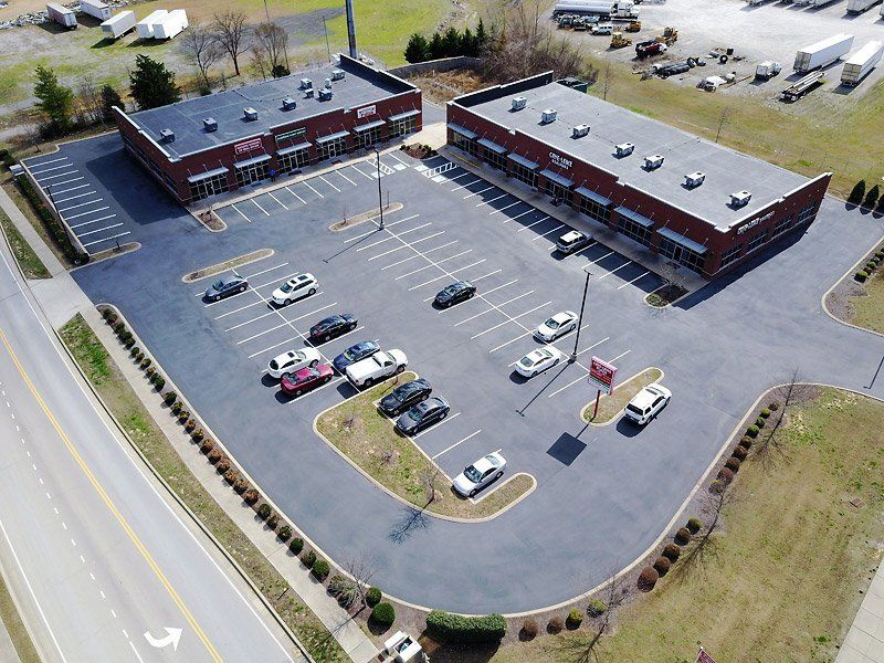 Top view of a commercial building with parking lots