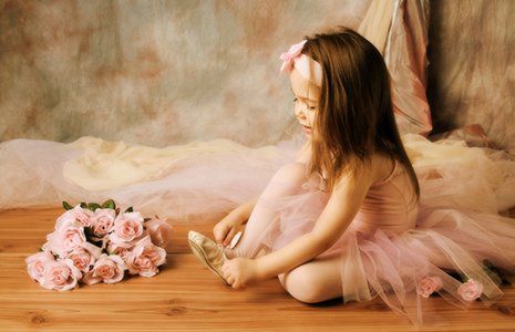 Little girl tying her ballet slippers