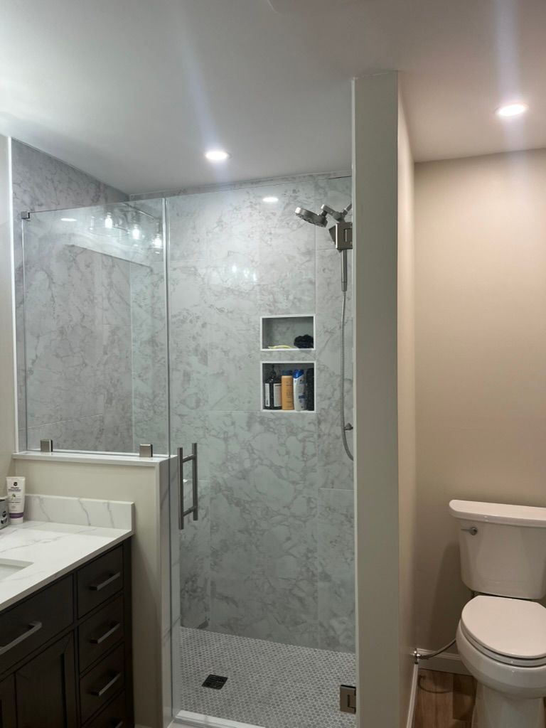 Woman in straw hat smiles, holding wine glass near a lake.