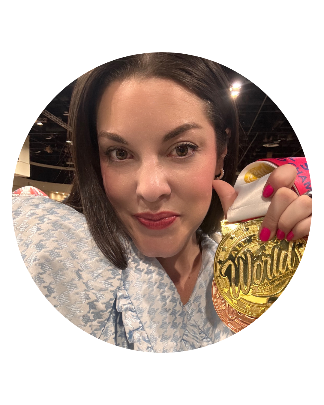 Woman holding a gold medal, pink lipstick, floral blouse.
