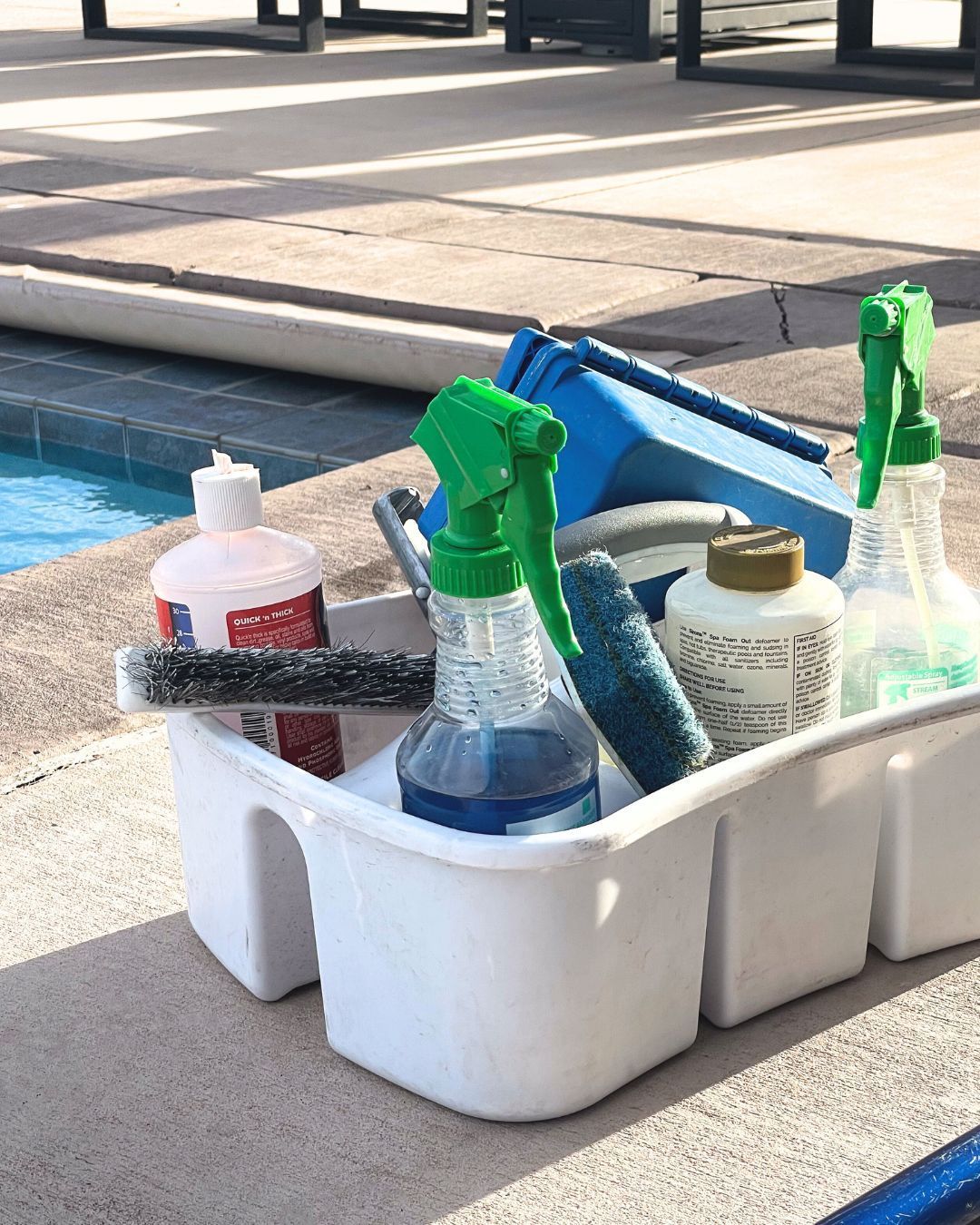 Pool cleaning supplies on the edge of a backyard pool in St. George, Utah.