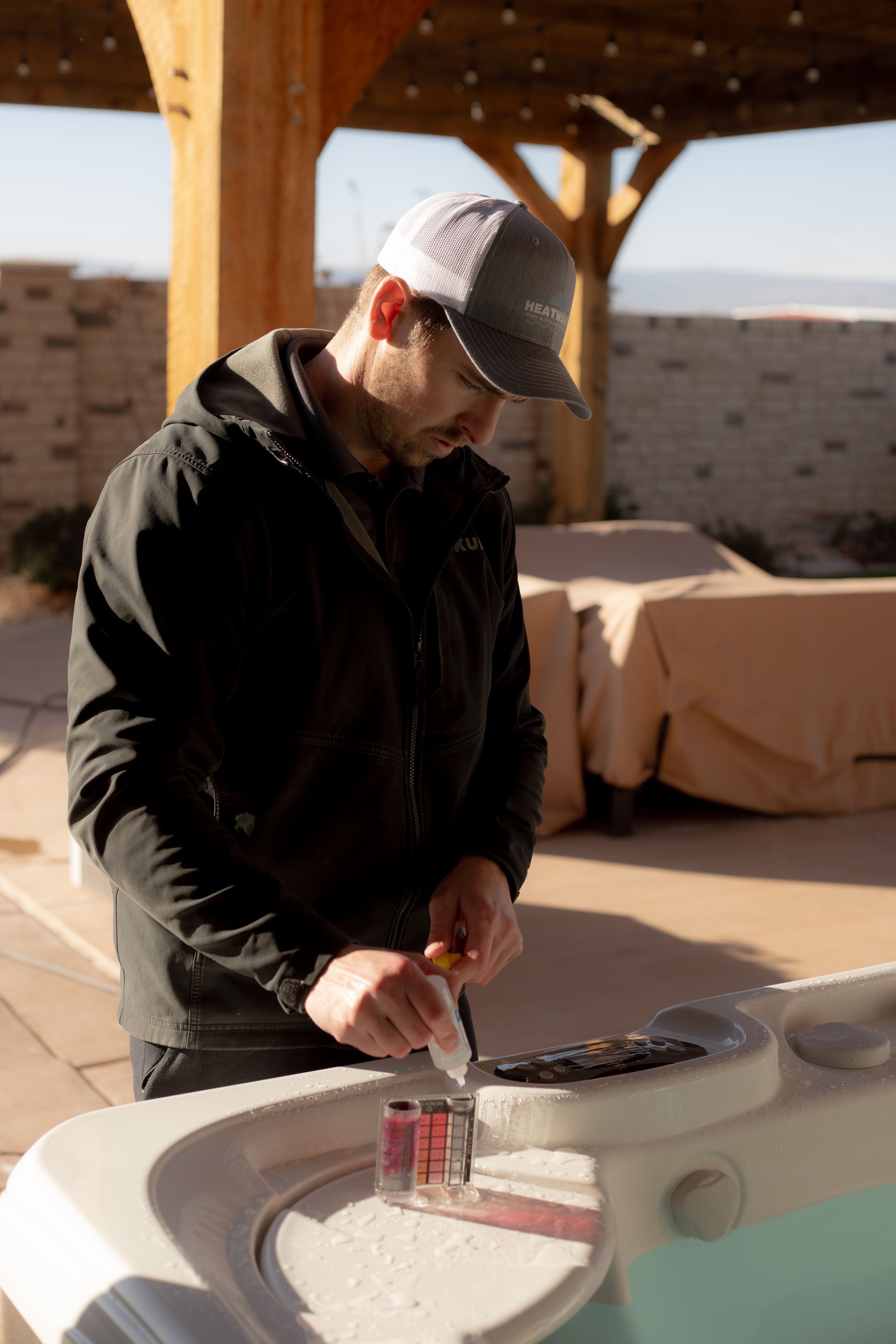 Pool boy in St. George Utah testing chemicals in a southern Utah backyard hot tub.
