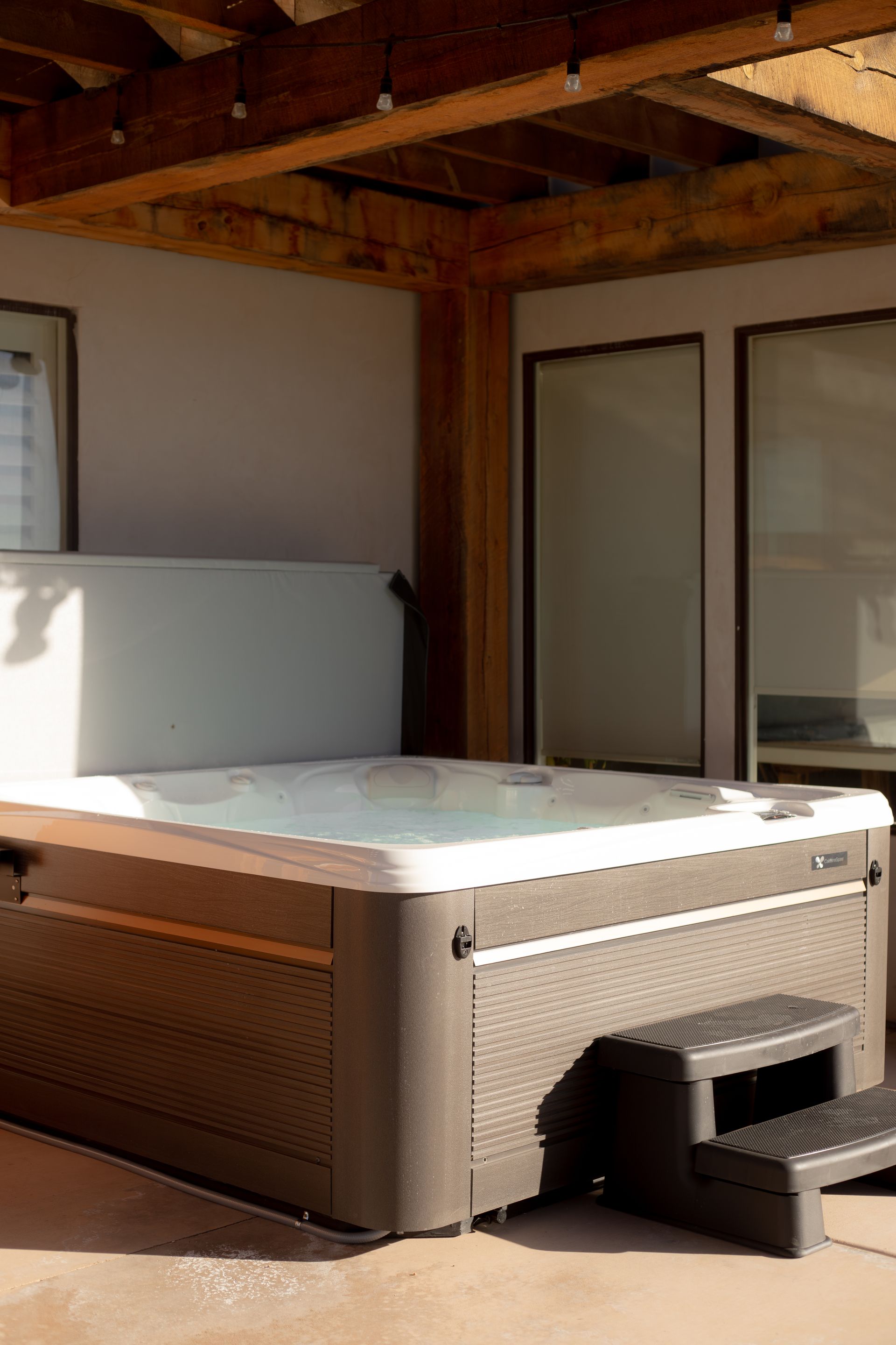 A pool boy preforming weekly hot tub cleaning a maintenance in a backyard hot tub in Southern Utah.