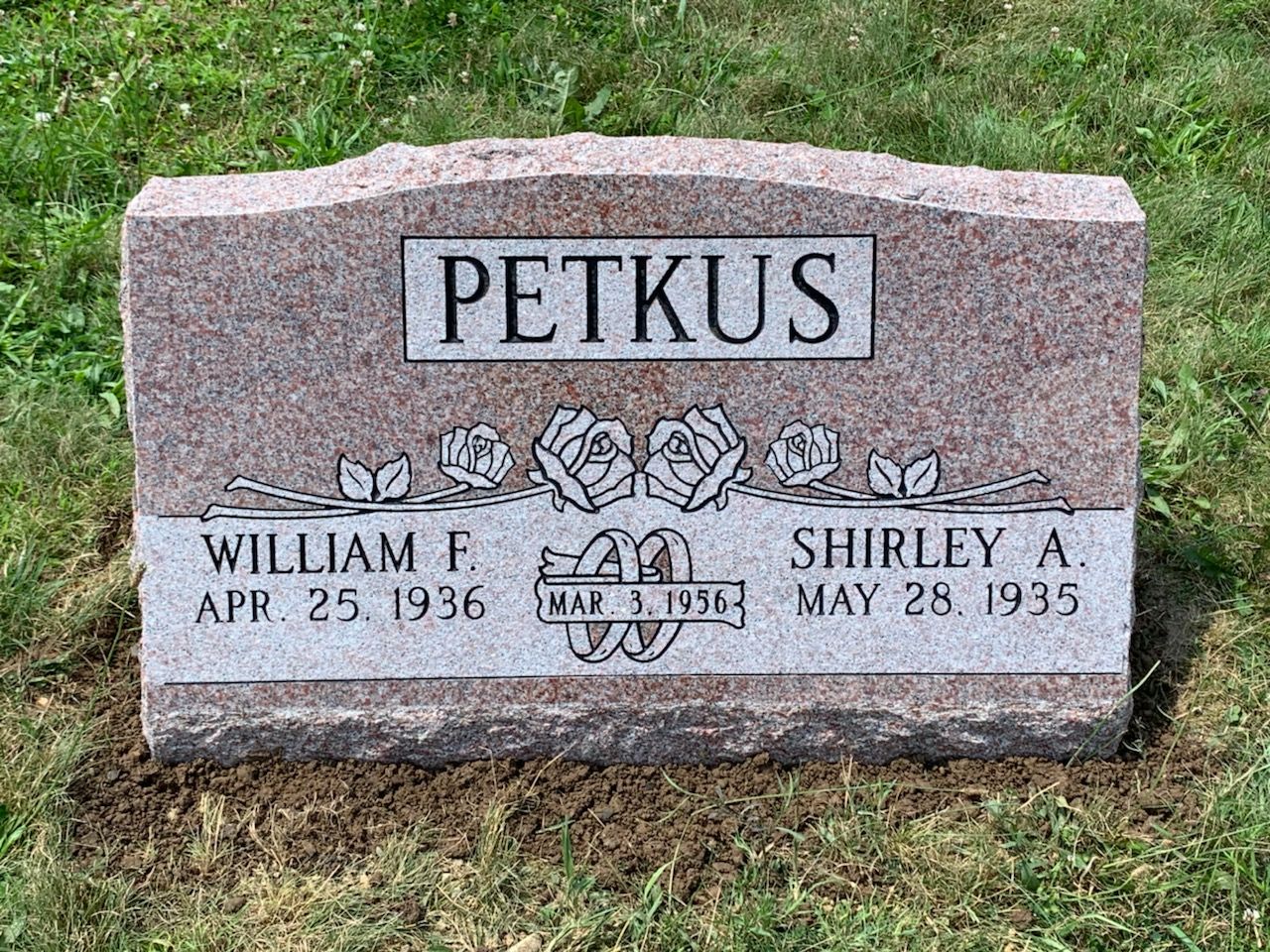 A gravestone for william f. petkus and shirley a. petkus in a cemetery.