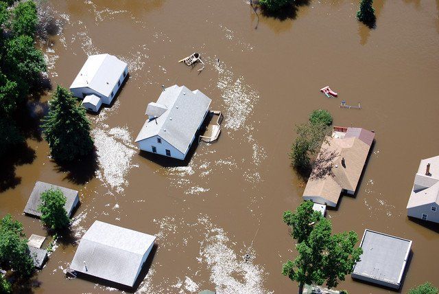 An aerial view of a flooded area with houses and trees