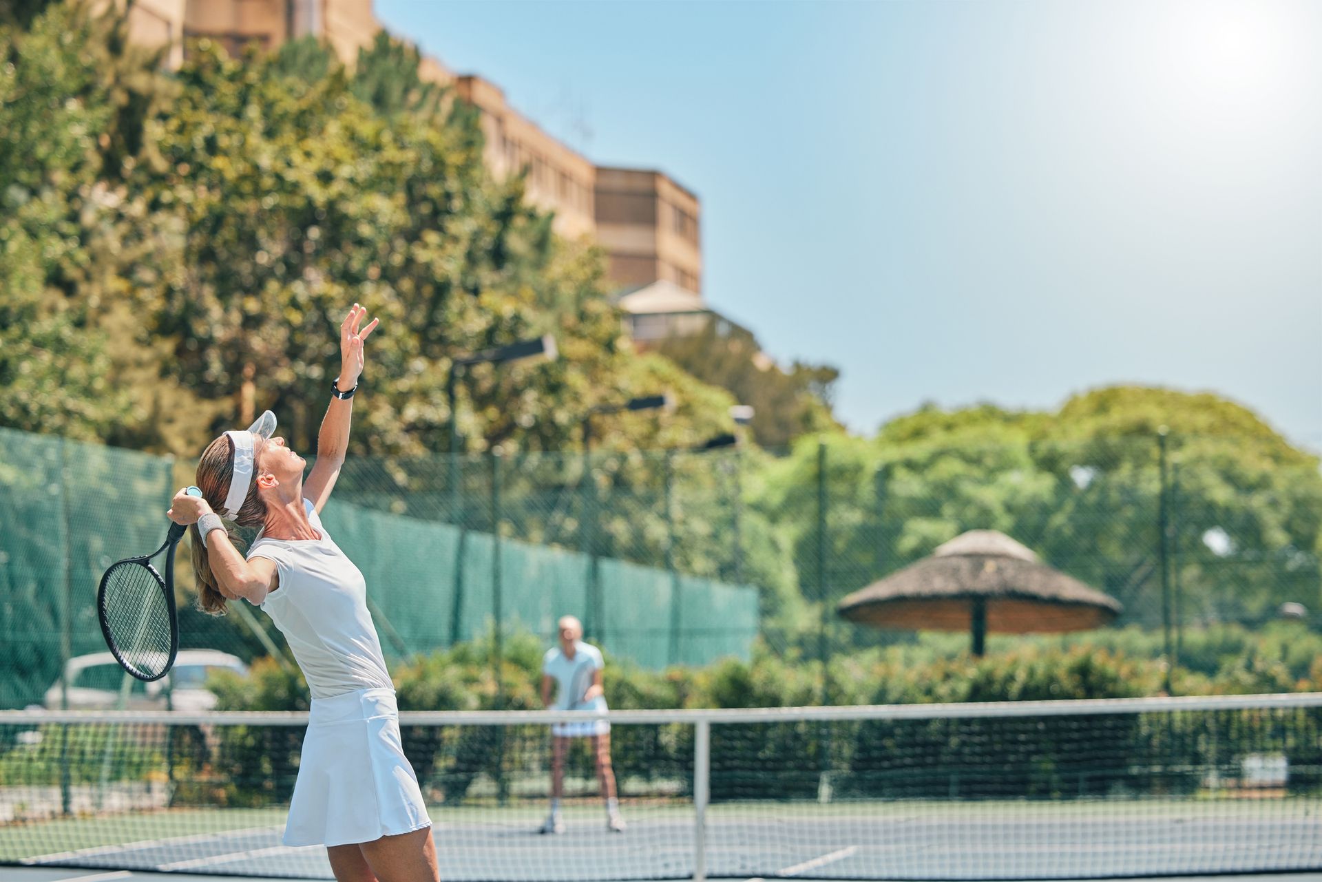 A woman is serving a tennis ball on a tennis court. A woman is serving a tennis ball on a tennis court.