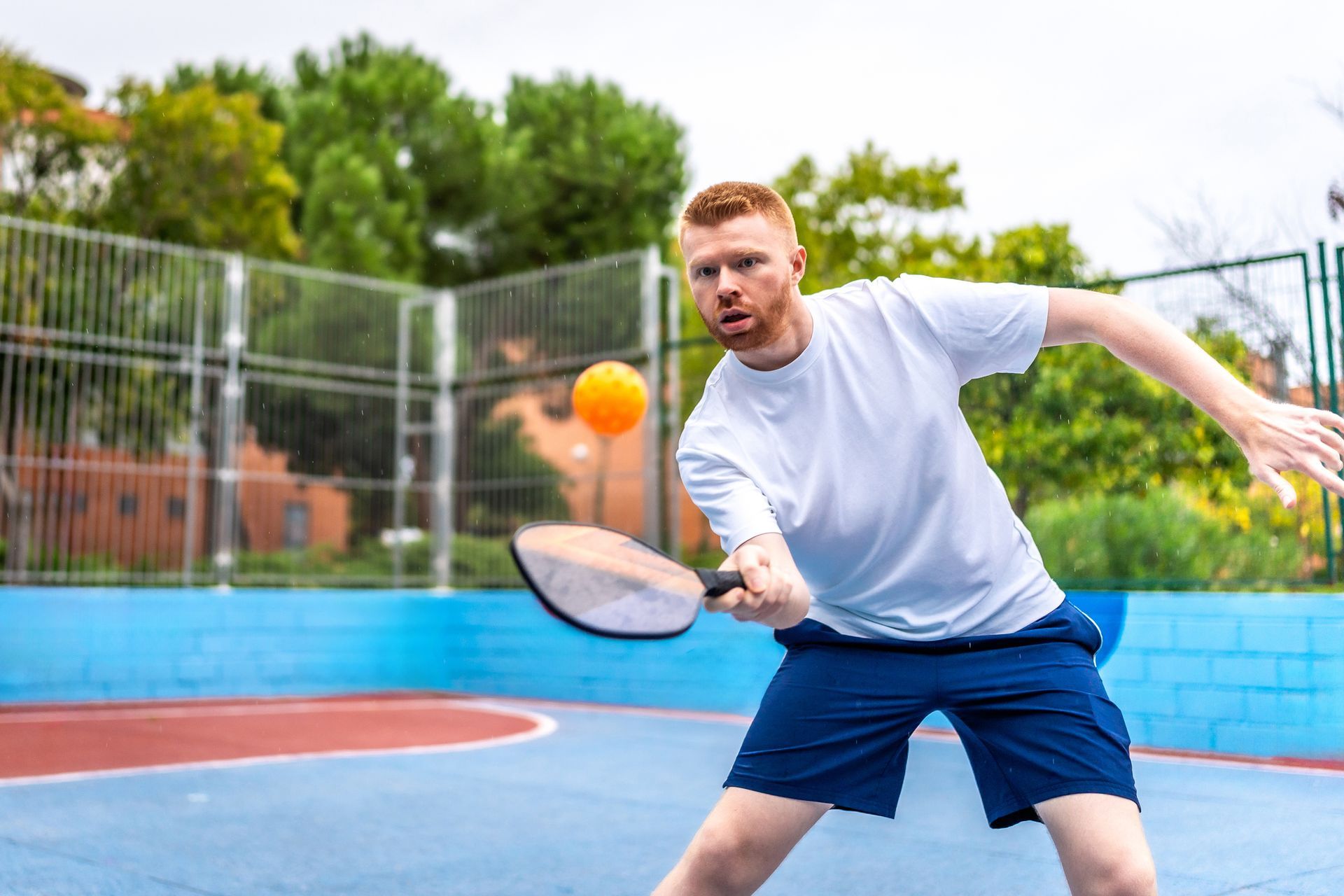 A man is playing a game of paddle tennis on a court. A man is playing a game of paddle tennis on a court.
