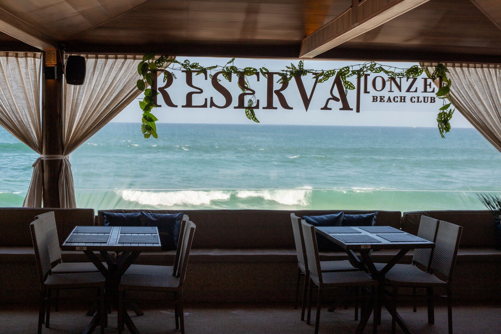 Um restaurante com vista para o mar. A placa diz 