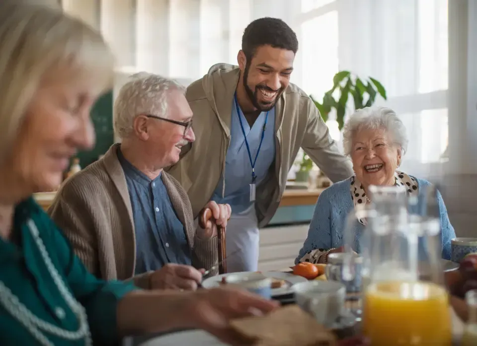Oaklands Residential Care Home, Methley, Leeds | A man is standing next to a group of elderly people sitting at a table.