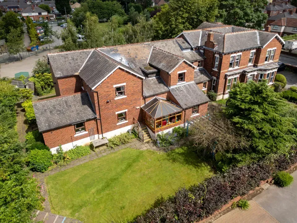 Oaklands Residential Care Home, Methley, Leeds | An aerial view of a large brick house with a large lawn in front of it.
