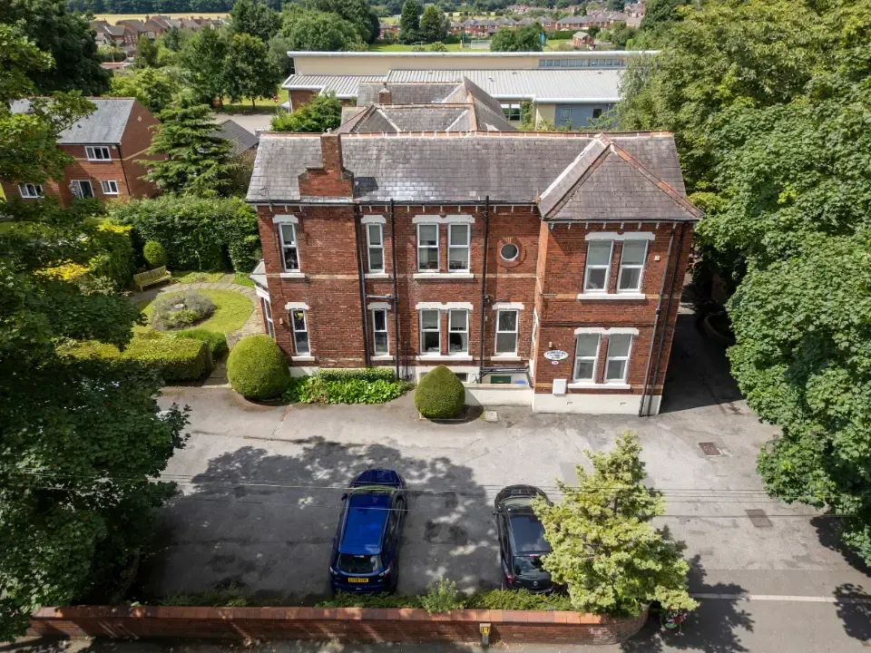 Oaklands Residential Care Home, Methley, Leeds | An aerial view of a large brick house with cars parked in front of it.