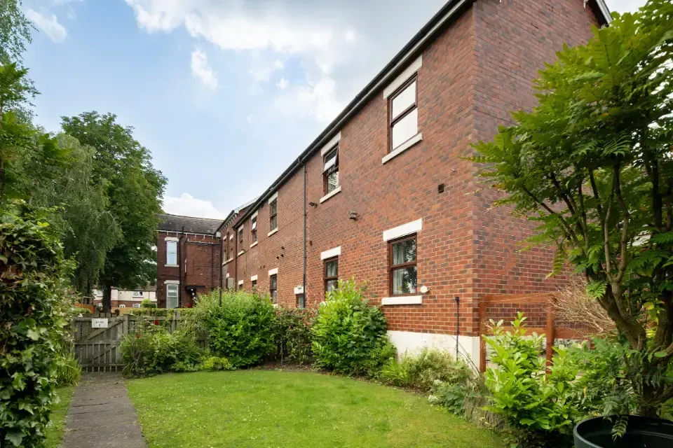 Oaklands Residential Care Home, Methley, Leeds | A brick building with a lush green lawn in front of it.