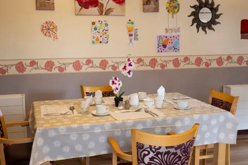 Oaklands Residential Care Home, Methley, Leeds | A dining room with a table and chairs and a table cloth.