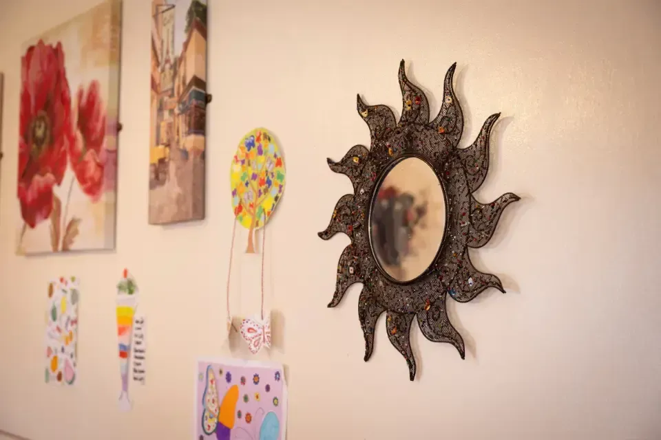 Oaklands Residential Care Home, Methley, Leeds | A mirror in the shape of a sun is hanging on a wall.