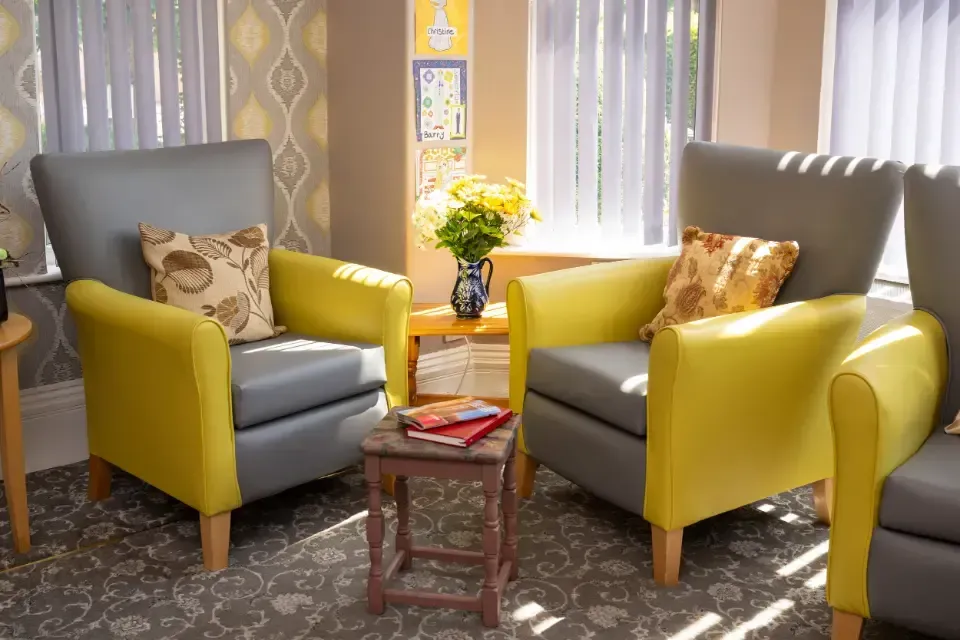 Oaklands Residential Care Home, Methley, Leeds | A living room with two yellow chairs and a table.