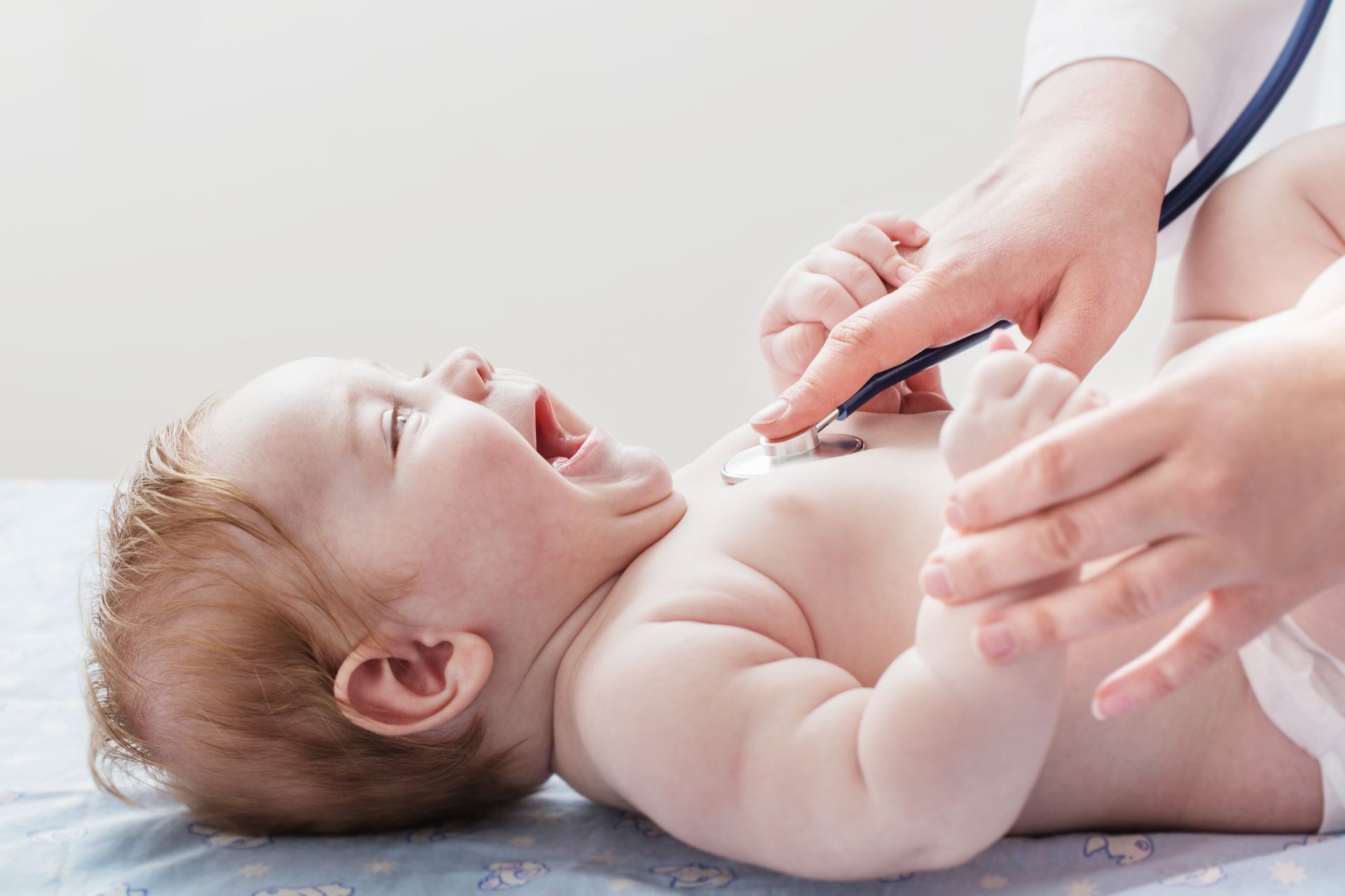 Doctor listens to small child with stethoscope