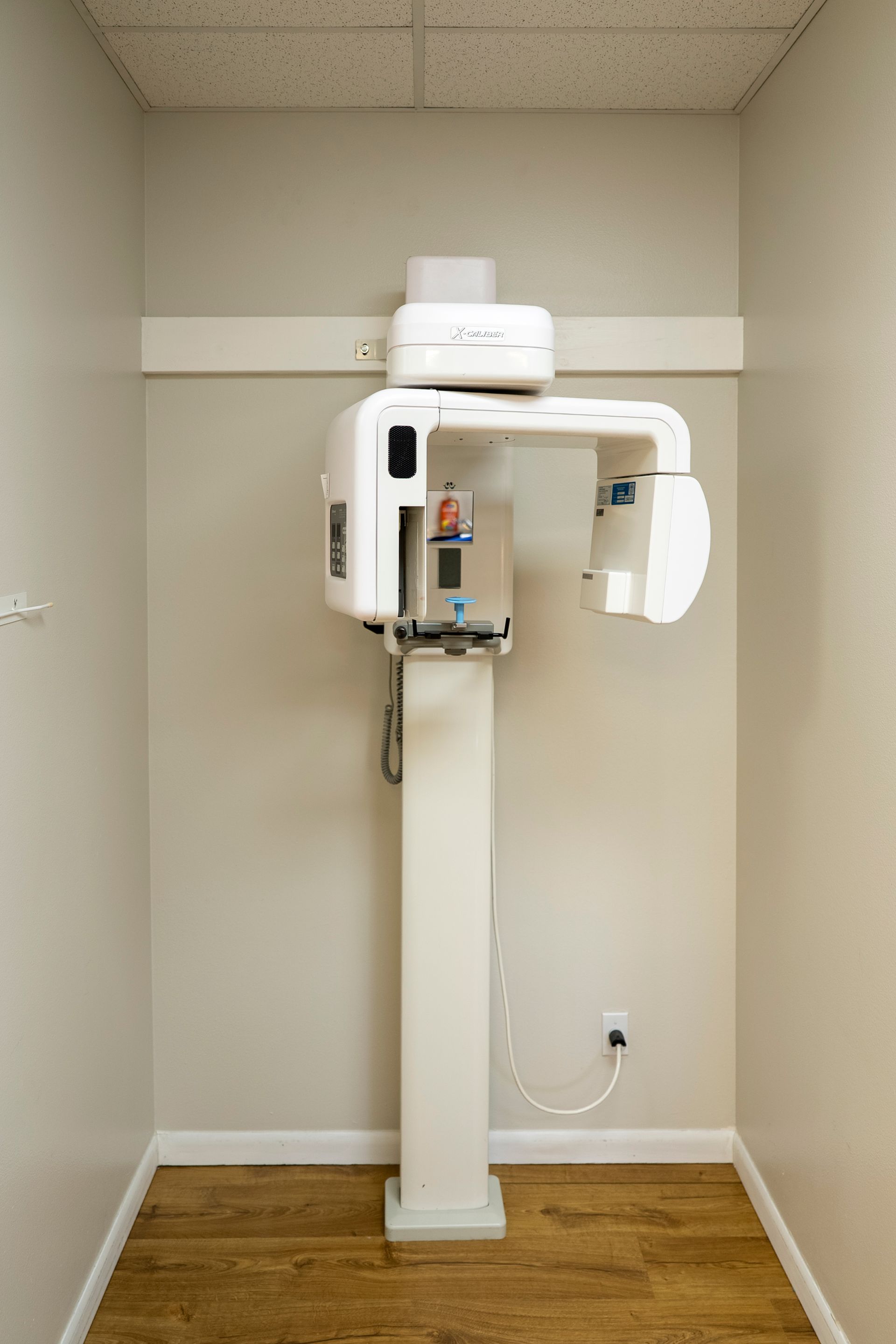 Waiting room with teal chairs, window with blinds, and neutral-colored walls.