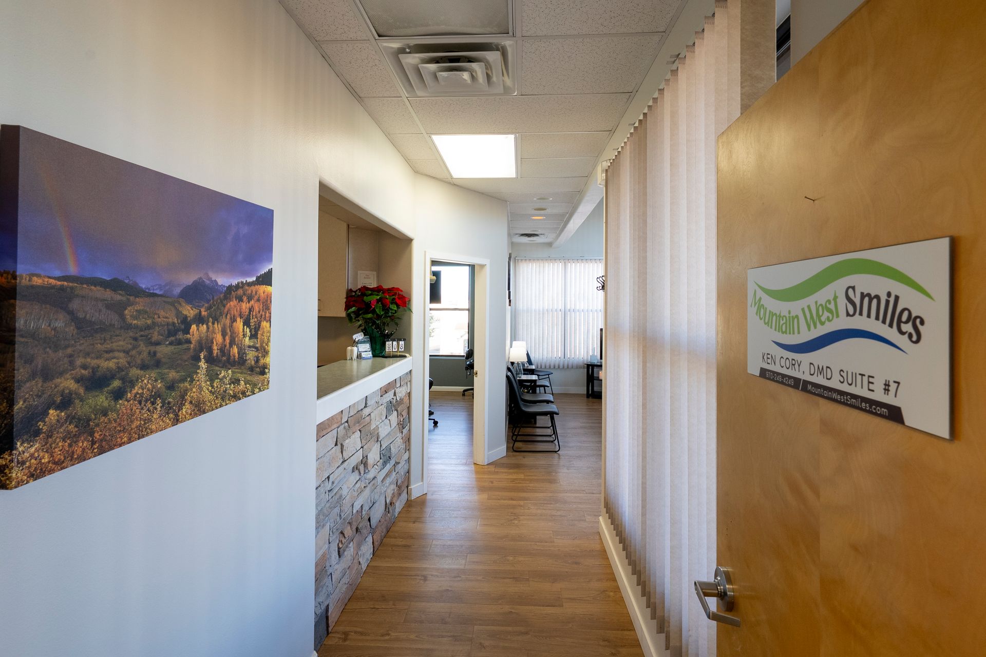 Dental examination room with teal chair, instruments, and beige cabinets.