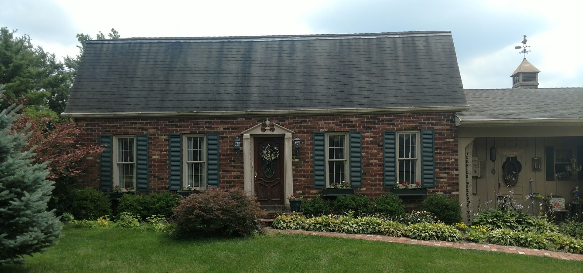 A brick house with blue shutters on the windows