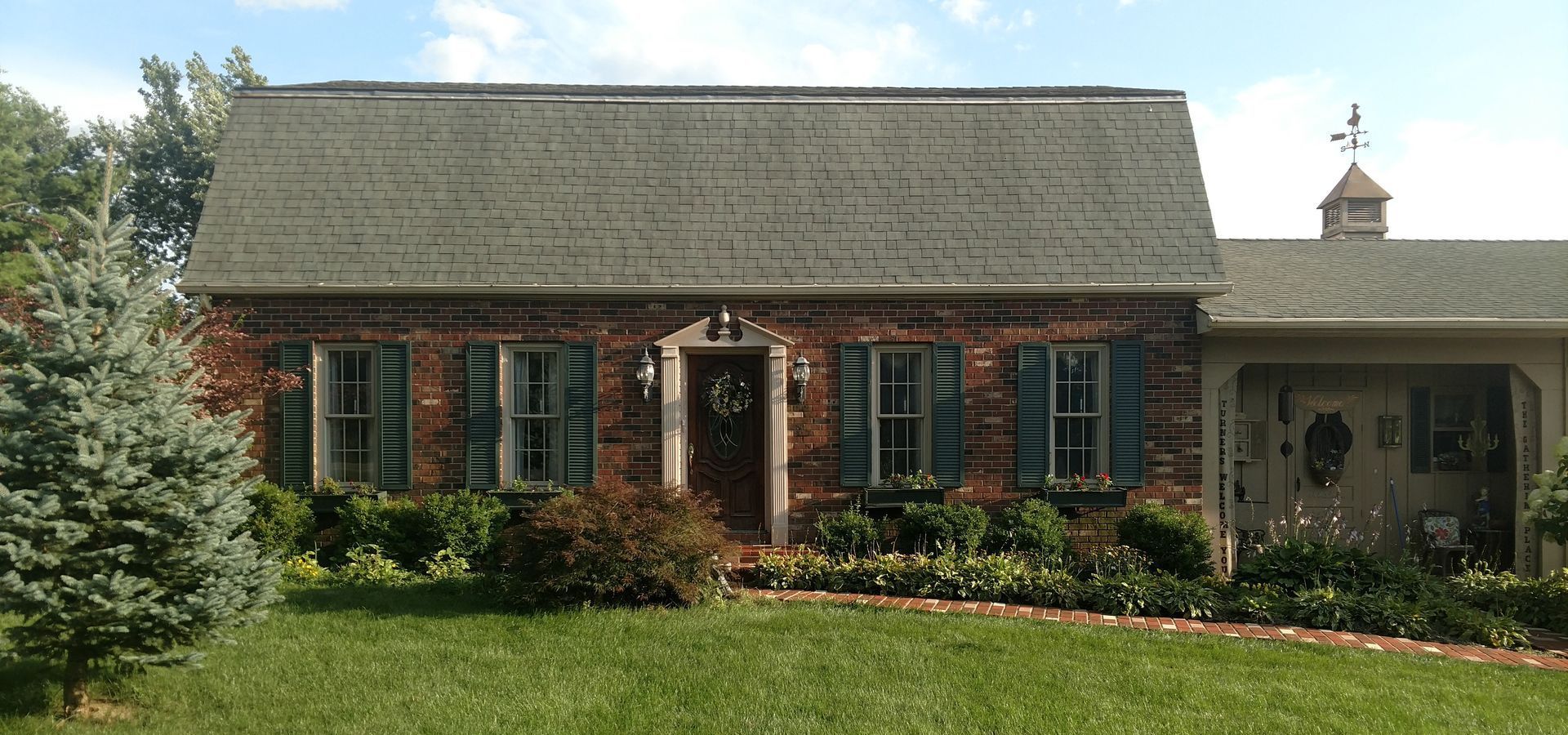 A brick house with blue shutters on the windows