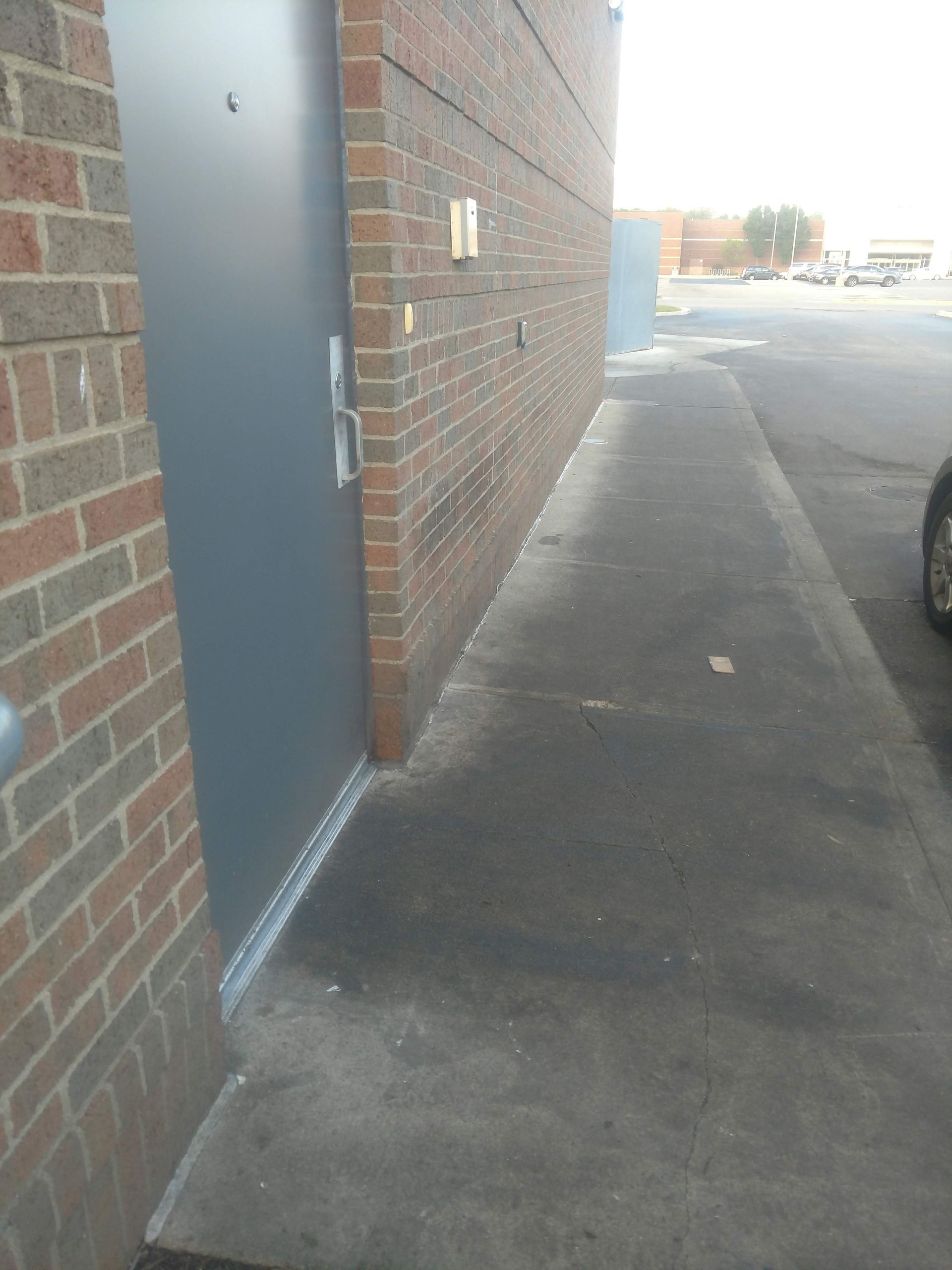 A car is parked in front of a brick building