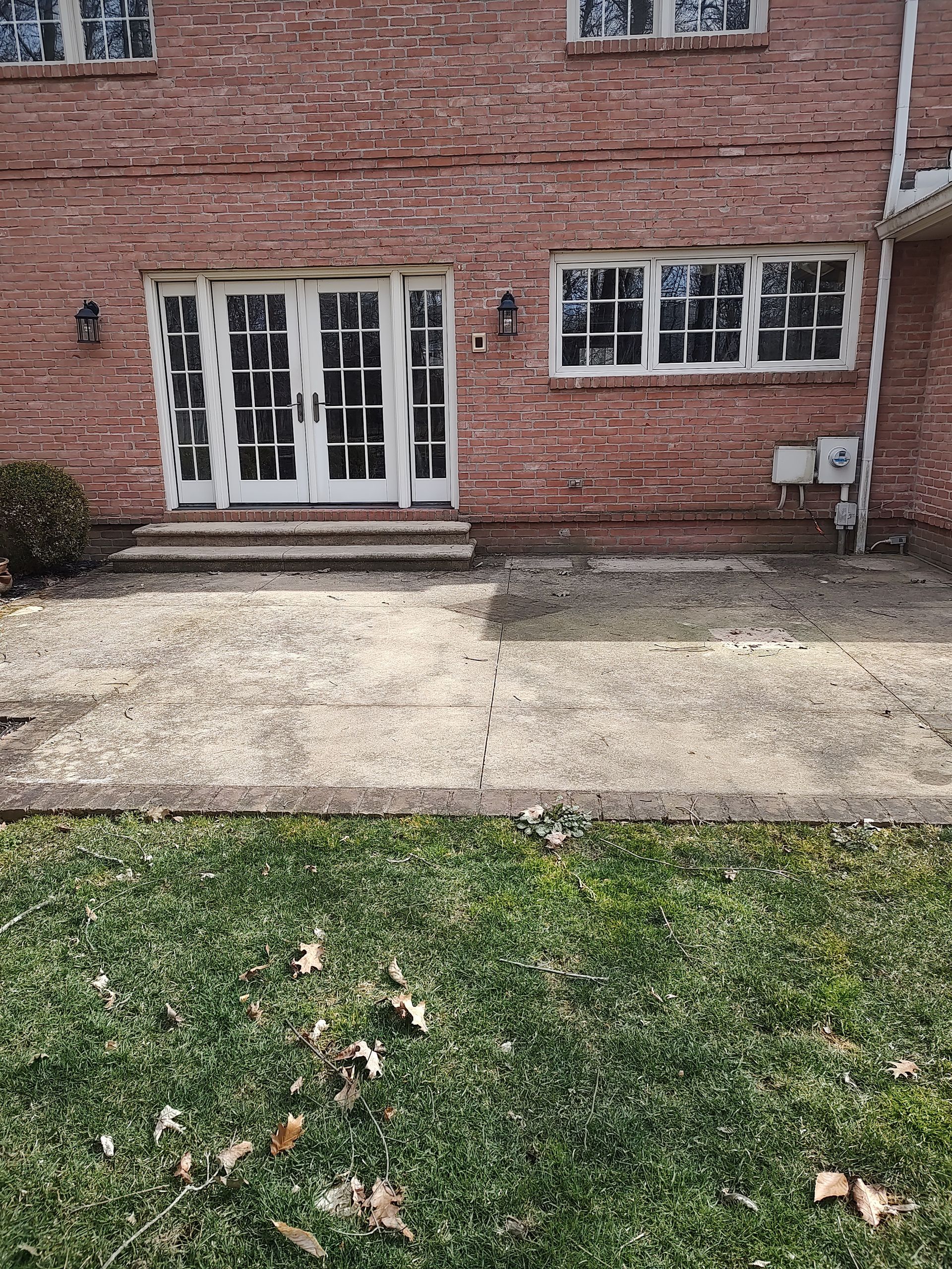 A brick house with a patio in front of it.