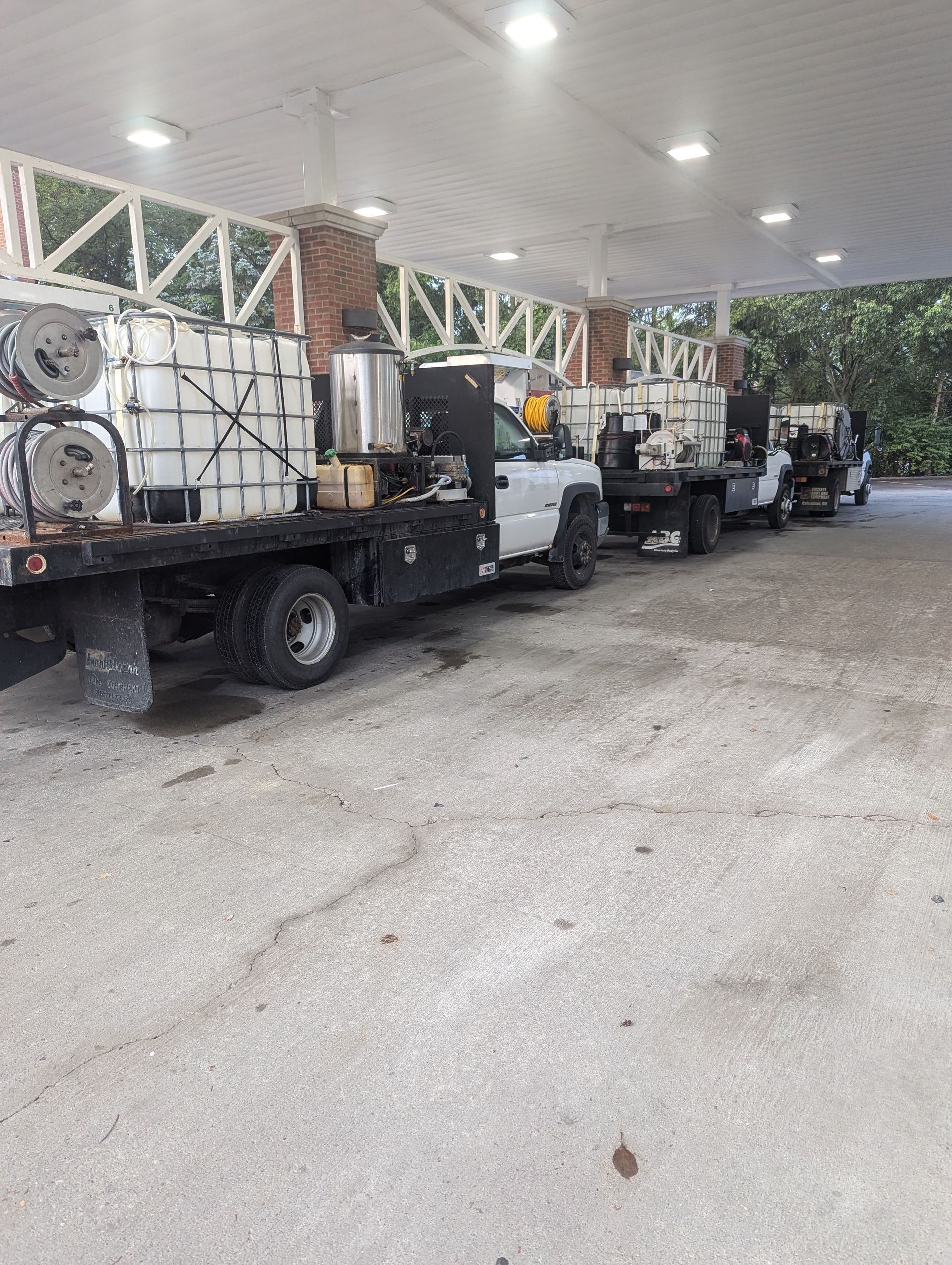 A row of trucks are parked in a parking lot.